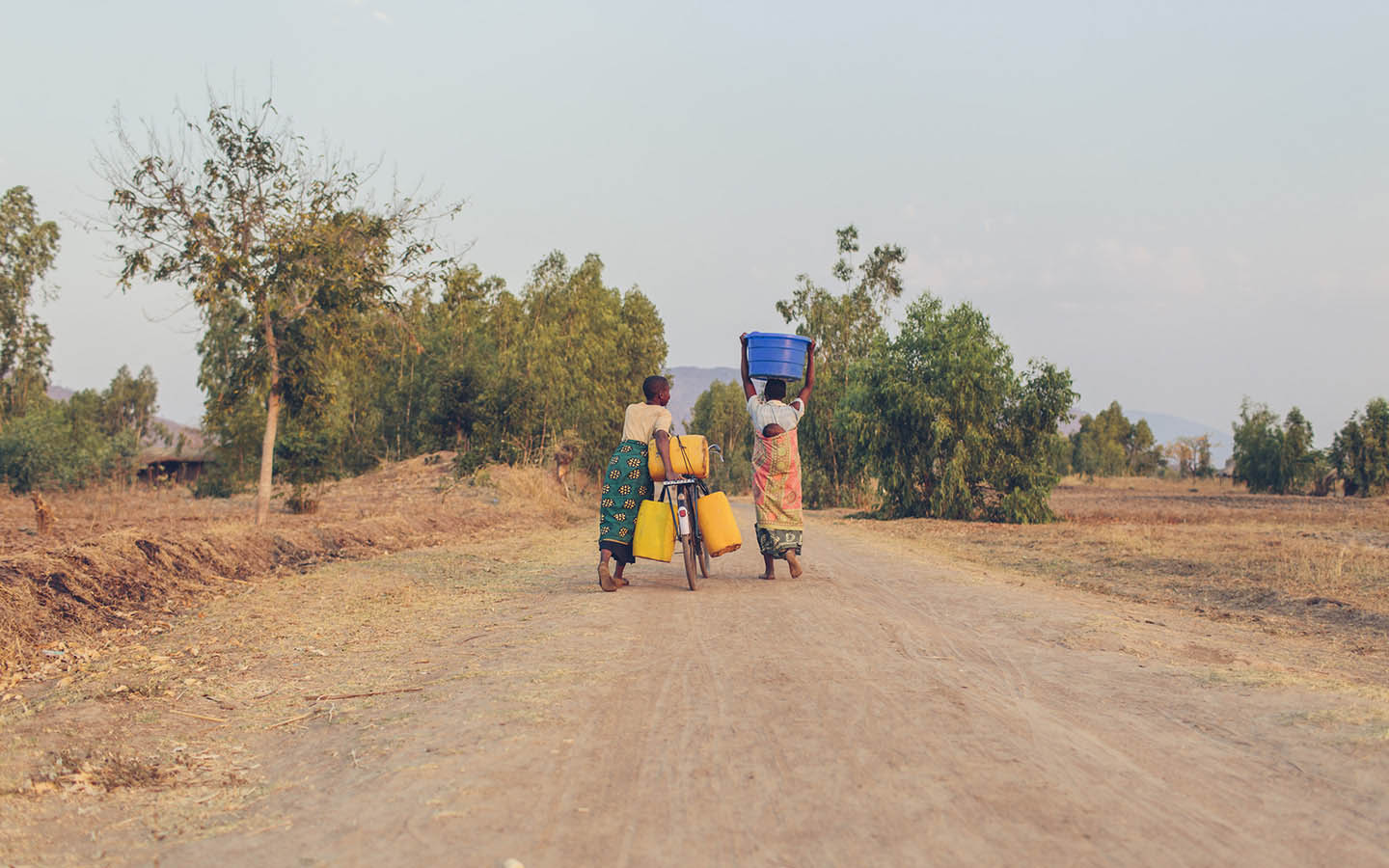 Women in Malawi Walk with Buckets of Water